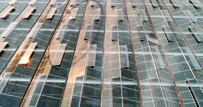 Vertical video: Shifting glare sliding across glass panes with mullions from clouds and cam drift