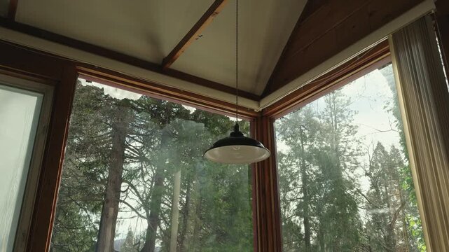 Peaceful view of a snowy forest through a rustic cabin corner window during spring thaw