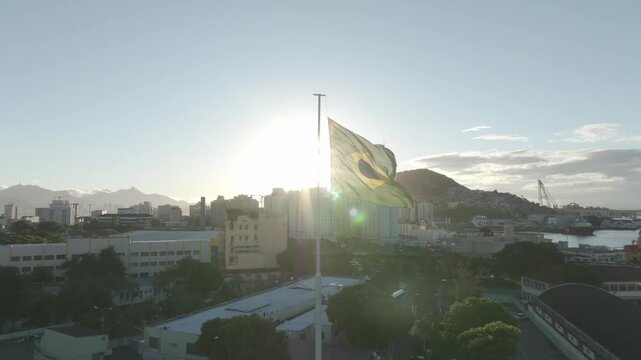 Bandeira do Brasil, voando ao vento com o sol de fundo.