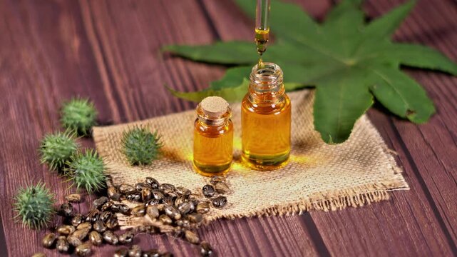 Pure Castor Oil Dripping into Bottle Alternative Medicine Concept. Plant Based Castor Oil in Bottle Eco Friendly Beauty Product. Cold Pressed Castor Oil for Hair Growth and Skin Care Close Up.