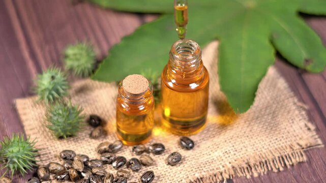 Castor Oil Droplet Falling into Bottle Natural Wellness and Skincare Concept. Close Up of Castor Oil Dropper with Herbal Leaves Natural Beauty Concept.