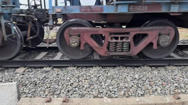 Railway Bogie and Steel Wheels on Track Transportation Industry Concept. Close View of Freight Train Wheels on Railway Track Mechanical Detail. Indian Railway Line with Indian Train Transportation. 