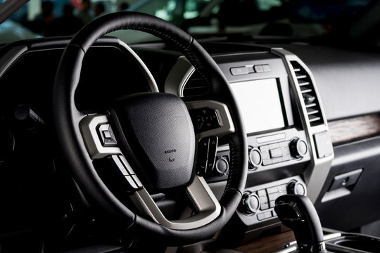 Modern pickup truck interior, touch screen panel, leather seats and automatic transmission lever - dark light