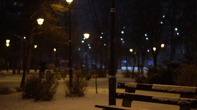 Solitary Person Pauses Under Winter Sky. Alone Figure Halts Amidst Snow And Cold Shadows In Silent Park