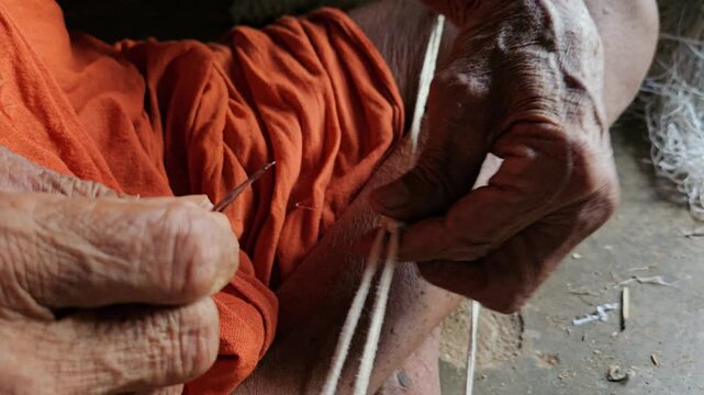 Elder Indian Brahmin making sacred thread janeyu by hand. Traditional Hindu ritual craft showing cultural heritage, spirituality, and authentic lifestyle.