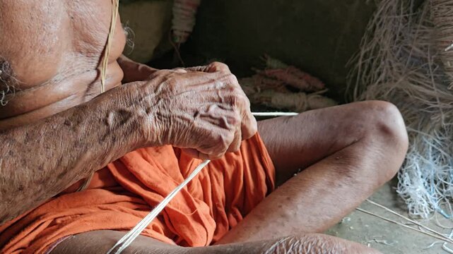 Elder Indian Brahmin making sacred thread janeyu by hand. Traditional Hindu ritual craft showing cultural heritage, spirituality, and authentic lifestyle.