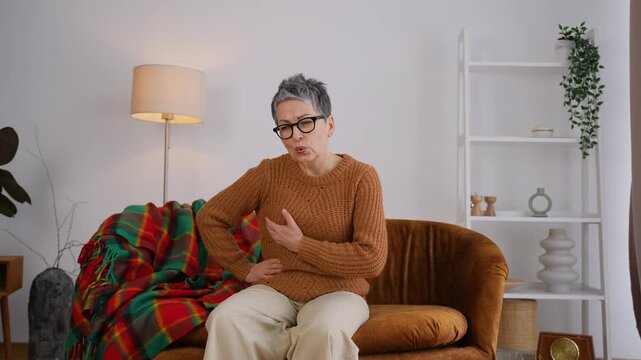 Elderly woman suffering from chest pain having a heart attack at home