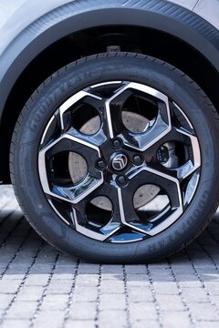Brecht Belgium - 10 October 2025: High-detail closeup of a car wheel featuring a Goodyear tire and glossy alloy rim on a paved cobblestone surface, highlighting tread, brake disc, reflections and mode