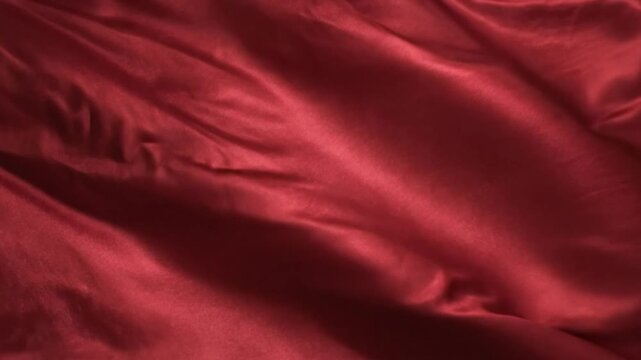 Luxurious red satin fabric flowing and waving gently creating a soft and elegant background texture for design and motion graphics