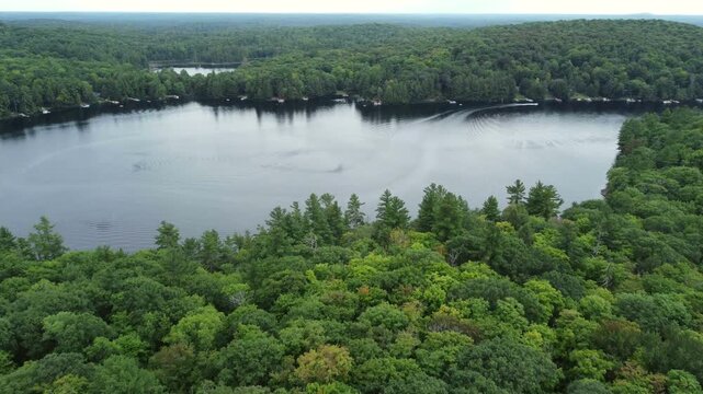 Flying over Buckskin Lake south on an overcast, late summer afternoon. Aerial above the expansive wilderness of crown land located in the Tory Hill area of Highlands East, in southern Ontario, Canada.