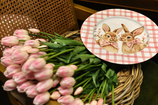 Easter. A bouquet of pink tulips and a plate with cute bunnies. Spring flowers. Spring Easter decor.