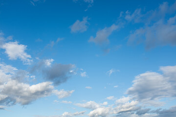 Fototapeta premium Blue sky with white clouds background, soft cloudy sky texture, sunny weather, natural atmosphere, minimal nature backdrop with copy space