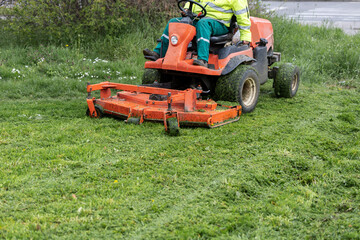 Obraz premium Front view of ride on mower cutting freshly trimmed lawn