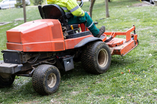 Rear view of commercial mower working on park grass
