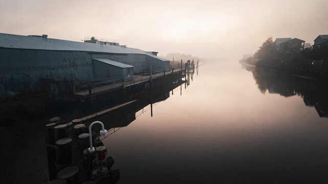 Morning fog over Petaluma River waterfront with reflections, Northern California