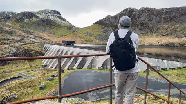Solo Backpack Hiker at Stwlan Dam Lake Reservoir in the Moelwyn Mountains, Snowdonia National Park, Blaenau Ffestiniog, Gwynedd, North Wales, UK