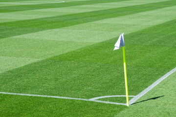 Well-Maintained Football Stadium Pitch with Striped Grass Under Clear Blue Sky © minortica7