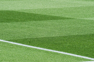 Obraz premium Well-Maintained Football Stadium Pitch with Striped Grass Under Clear Blue Sky