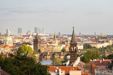Obraz premium Panoramic view of Prague skyline featuring historic architecture, Vltava River, and modern buildings under a clear sky during daytime
