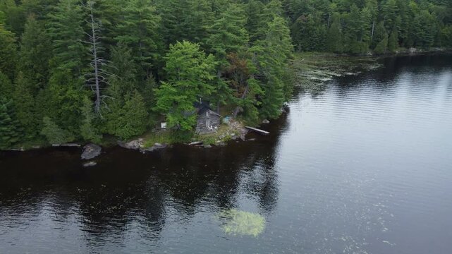 Flying over Buckskin Lake towards an old hunting lodge on an overcast, late summer afternoon. establishing shot aerial within the expansive crown land wilderness, located in the Tory Hill area of High