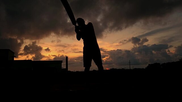 Cricket Player Silhouette Playing Shot at Sunset in India | Slow Motion Sports Scene