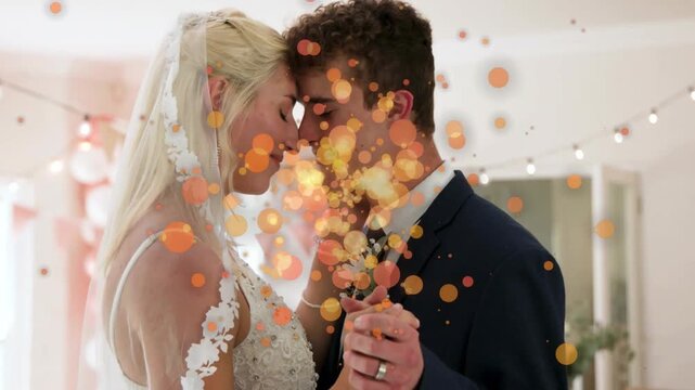 Bride and groom pressing foreheads, holding hands at wedding, causing gold particles appearing