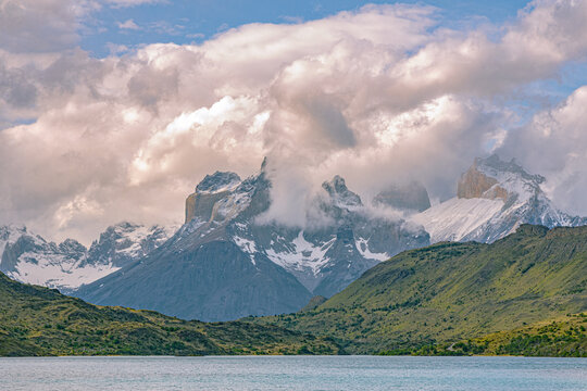 Heavy clouds roll over the jagged peaks of Torres del Paine in Patagonia, Chile. The moody atmosphere and rugged terrain showcase one of South America&rsquo;s most iconic mountain landscapes.