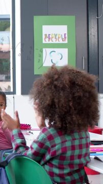 Vertical video: Teacher starting curly kid turning, clapping with peer, learning while math showing