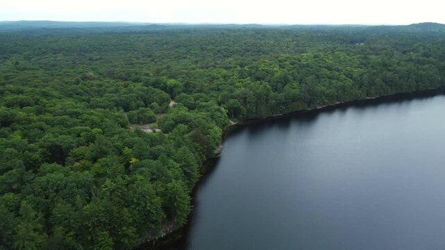 Flying over Buckskin Lake in a circular motion on an overcast, late summer afternoon. Aerial above the expansive crown land wilderness, located in the Tory Hill, Highlands East, Ontario, Canada.