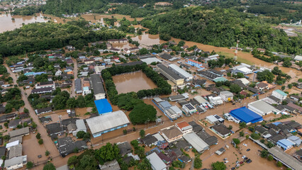 Obraz premium Aerial view of suburb area in Chiang Rai downtown flooding by Kok river after typhoon Yagi has swept Southeast Asia.