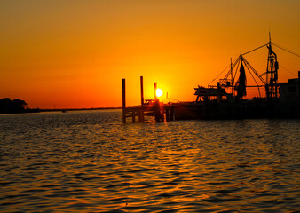 Naklejka premium sitting on the bay watching the sun disappear on the horizon