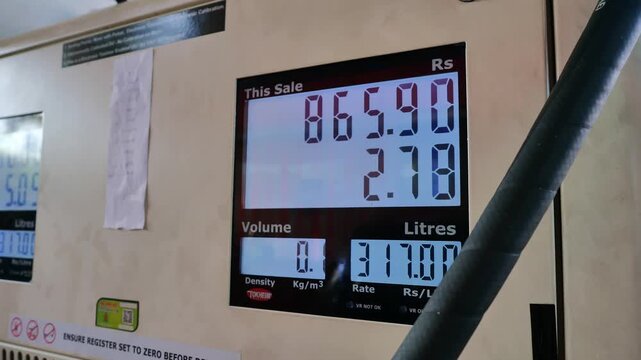 Close up of digital fuel pump display showing rising petrol prices, sale amount, volume in litres, and rate at gas station, illustrating global energy costs, economic inflation, transportation expense