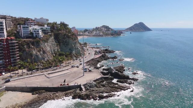 Explanada cerca del mar mostrando las Olas suaves romper contra las rocas, dando un panorama de costa urbana ideal para viajes y videos de paisajes marinos