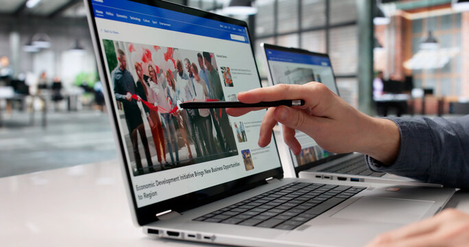 Young Journalist Reviewing Online News Articles On Laptop