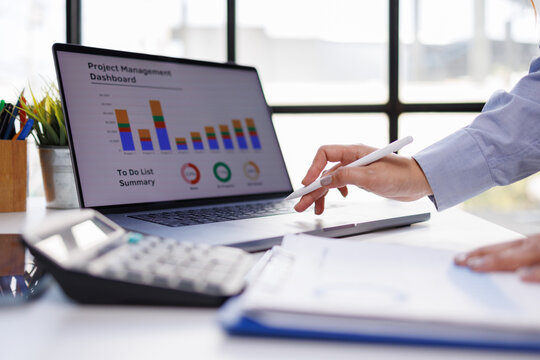 A close-up view of an engaged professional utilizing a laptop to analyze project management data, highlighting the importance of task organization and effective workflow.