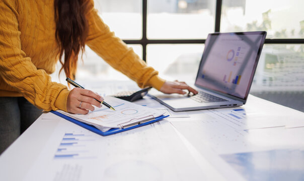 A person conducting an analysis of financial reports on a laptop, emphasizing the utilization of digital tools for data interpretation and informed decision-making.
