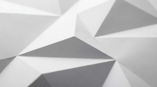 Abstract close-up photograph of white paper folded into a complex geometric triangular pattern and textured background.