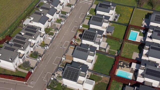 Modern Residential Estate: An aerial perspective reveals a contemporary housing development with rows of modern homes, solar panels, swimming pool, showcasing sustainable living and urban design.