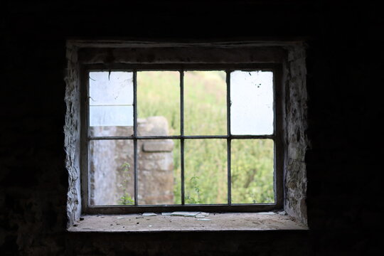 Looking through the window of an abandoned farmhouse