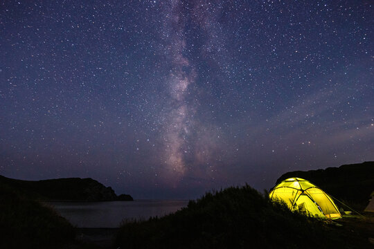 Tourist tent near the sea under the night sky with milky way.