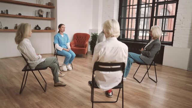 Physician appointment in modern clinic, group meeting with health professional. Group therapy for senior women, gynecologist or endocrinologist speaking and talking about female health after 60