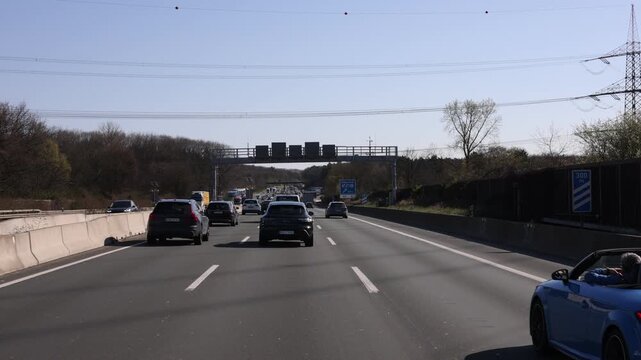 Crawling motorway traffic beside convertible near service area