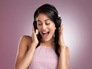 Fototapeta premium Headphones, surprise or woman with music in studio, streaming radio channel and listen to popular song. Audio tech, shocked and person with wow reaction for track selection, happy and pink background