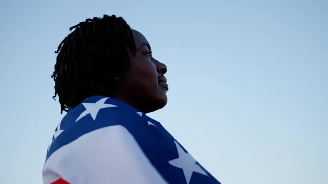 A person draped in an American flag gazes upward against a clear sky, evoking patriotism and reflection across eight sequential frames.