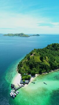 Vertical Drone Shot Flying Toward Kelor Island with Anchored Boats in Clear Blue Sea