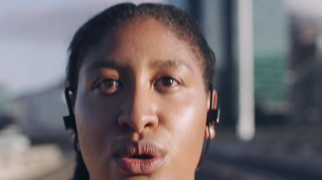 Earphones, exercise and running with woman on bridge in city for cardio training or workout routine. Fitness, music and streaming with runner outdoor in urban town for challenge, pace or sports