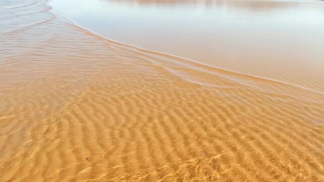 Serene beachscape with gentle waves on golden sand.