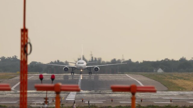 Footage of a jet passenger plane on the runway, front view. Approach Lighting System, ALS in the foreground