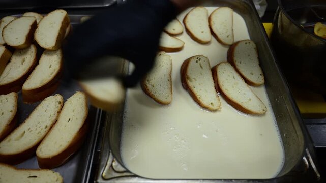 Restaurant chef soaking bread slices in milk