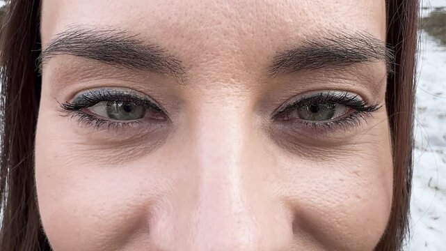 Close-up of female eyes with folds, natural eyebrows and long eyelashes, detailed beauty portrait, skin with pores and makeup on face